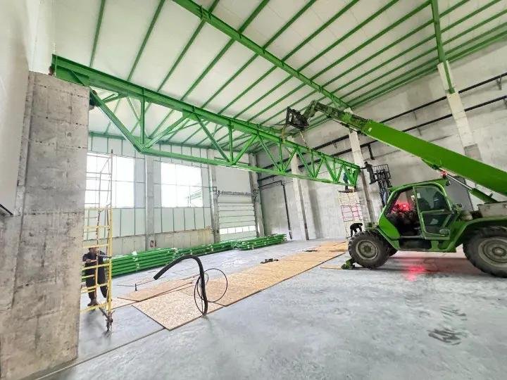 Structură metalică verde ridicată cu telehandler
