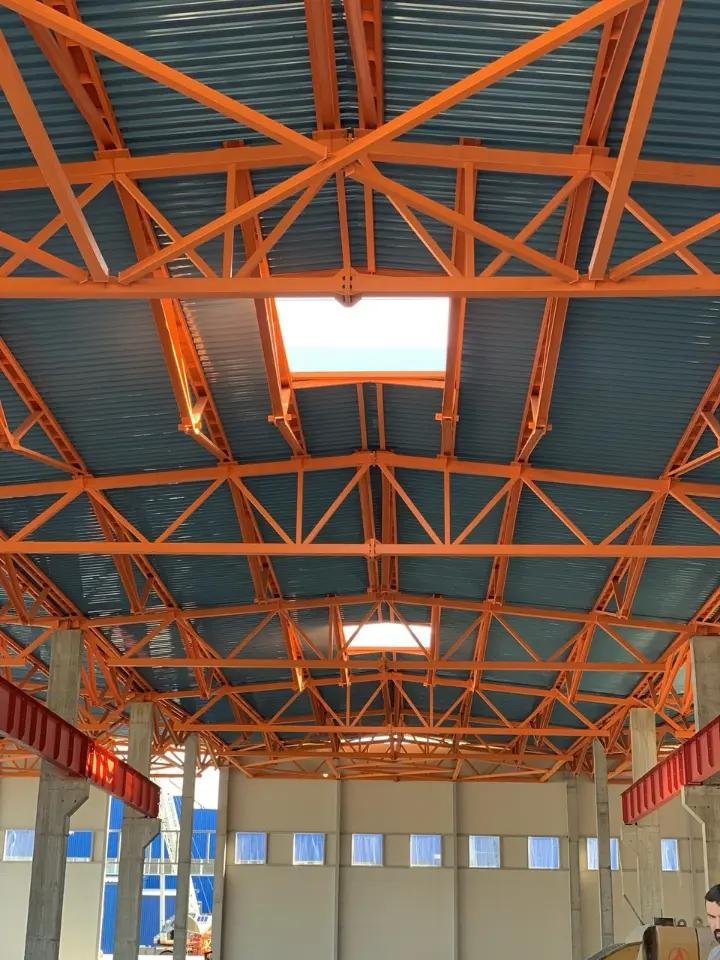Acoperiș pe fermă metalică portocalie, interior hală