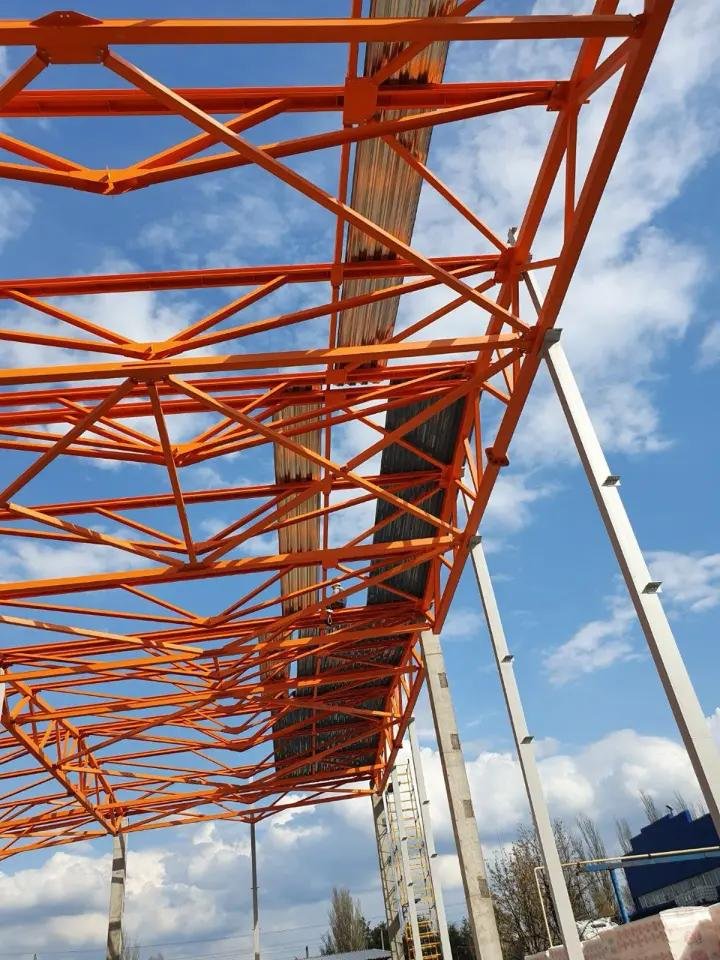 Fermă metalică portocalie pe fundal de cer albastru
